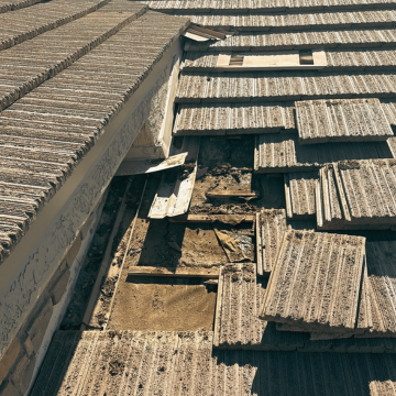 Professional roof repair Gilbert AZ showing damaged concrete tiles and underlayment exposure on a residential home.