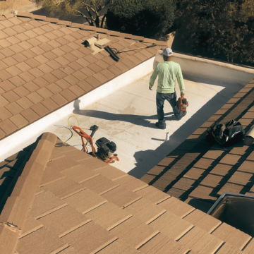 An expert from a licensed local roofing company near Scottsdale performing repairs on a residential flat roof section to provide the best roofing in Scottsdale.