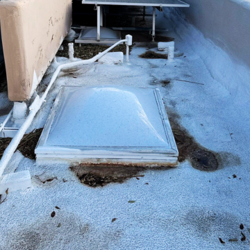 Professional arizona flat roof coating tempe, az applied to a commercial building with skylights.