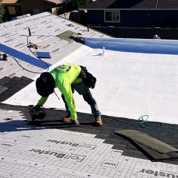 Expert roofers Gilbert az installing new asphalt shingles on a residential home alongside a white foam roof section.