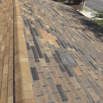 High-angle view of an asphalt shingle roof showing localized damage and a patched area, illustrating the need for a professional shingle roof installation phoenix. High-angle view of an asphalt shingle roof showing localized damage and a patched area, illustrating the need for a professional shingle roof installation phoenix.