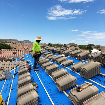 Worker installed blue underlayment and stacked roof tiles with tile roof contractors chandler az.
