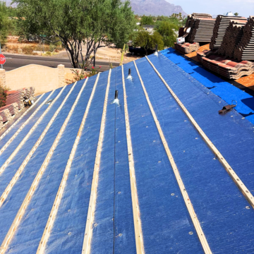 Sloped roof deck fitted with blue synthetic underlayment and wooden battens by a roofing contractor Phoenix AZ.