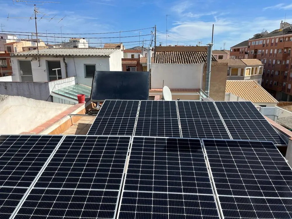 Placas solares sobre una terraza plana entre tejados del casco urbano