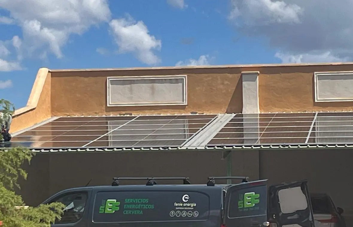 La furgoneta rotulada de Servicios Energéticos Cervera bajo una marquesina con placas solares
