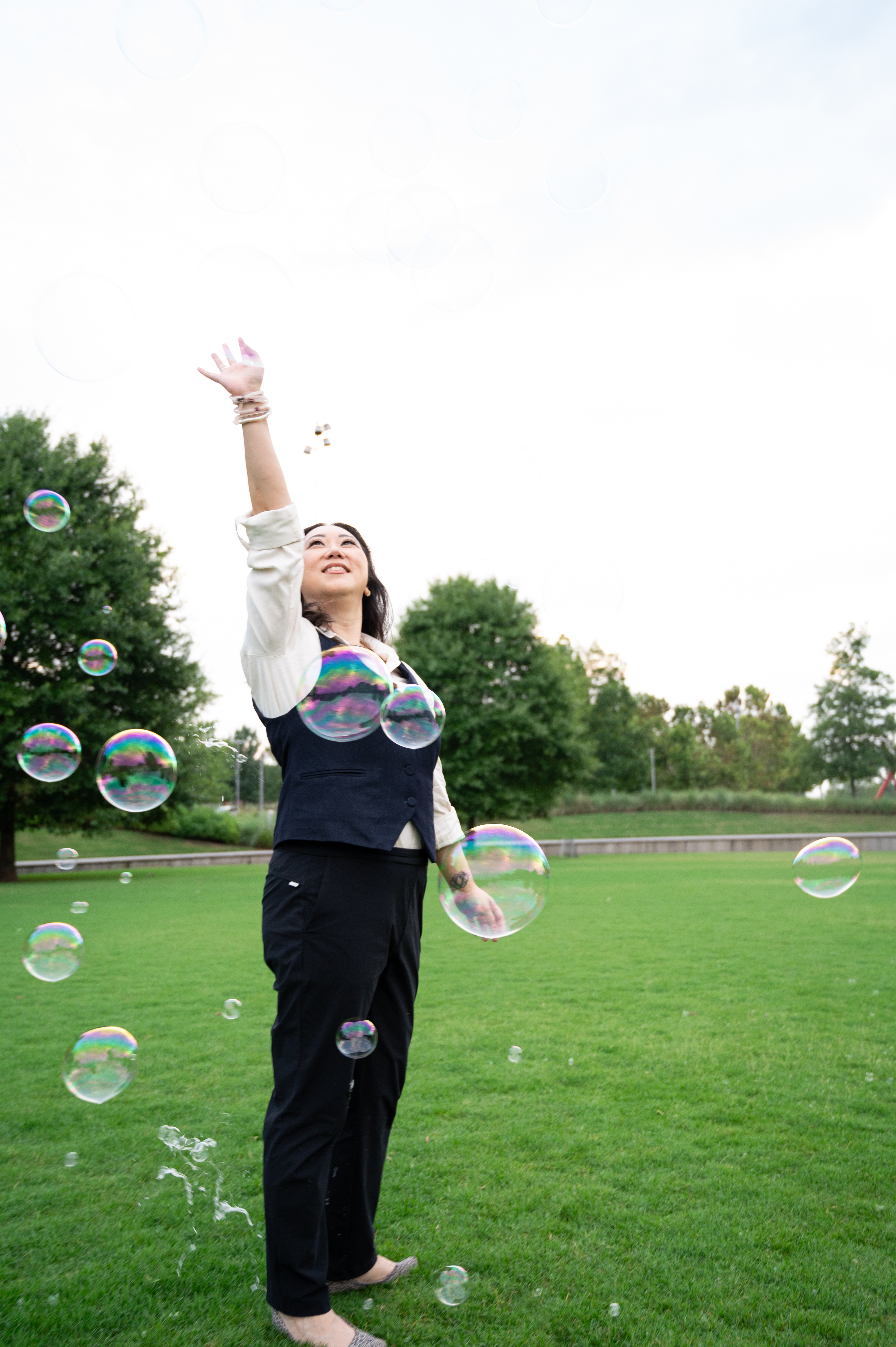 Sora reaching toward bubbles outdoors