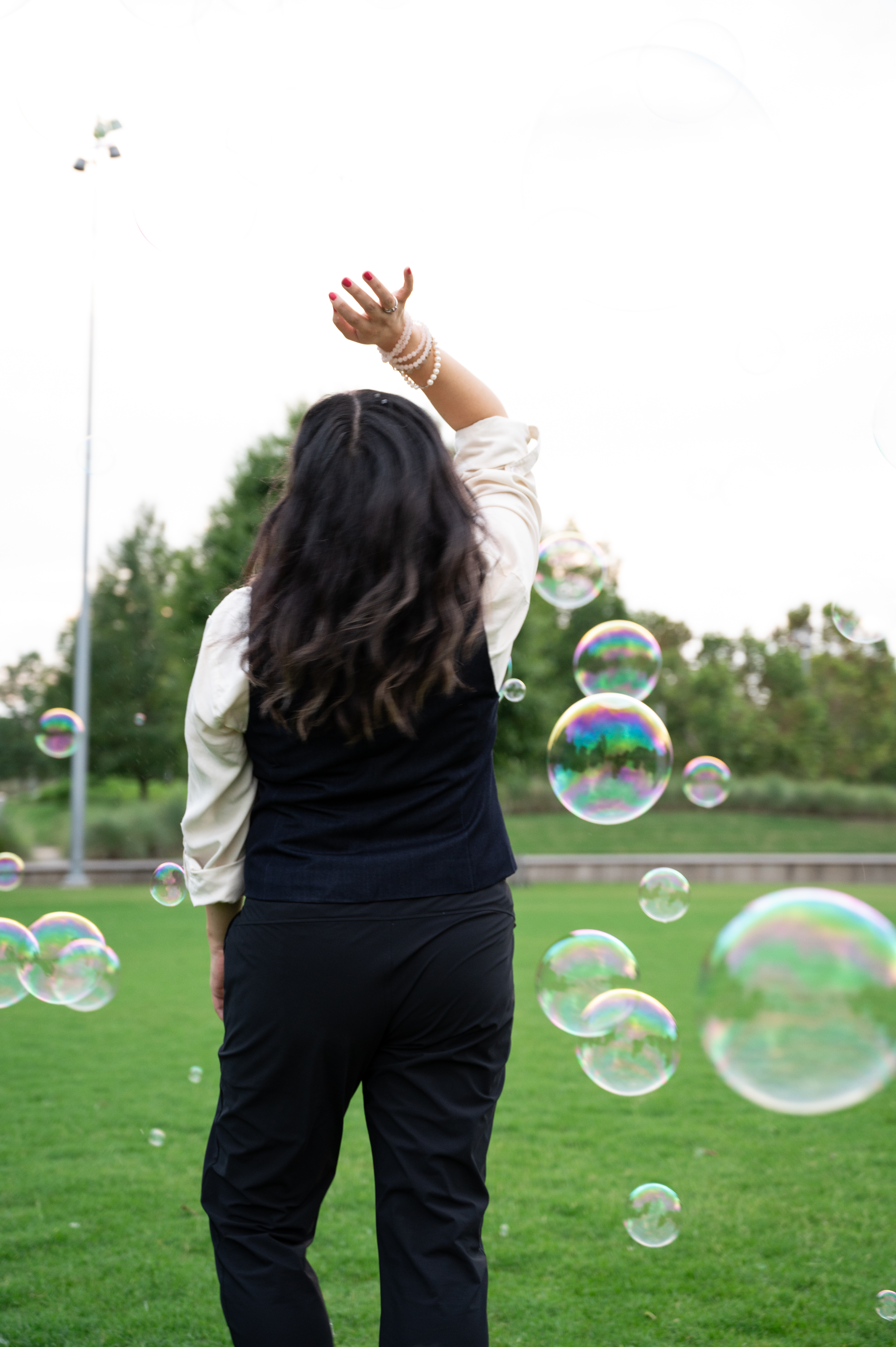 A woman reaching into a field of bubbles