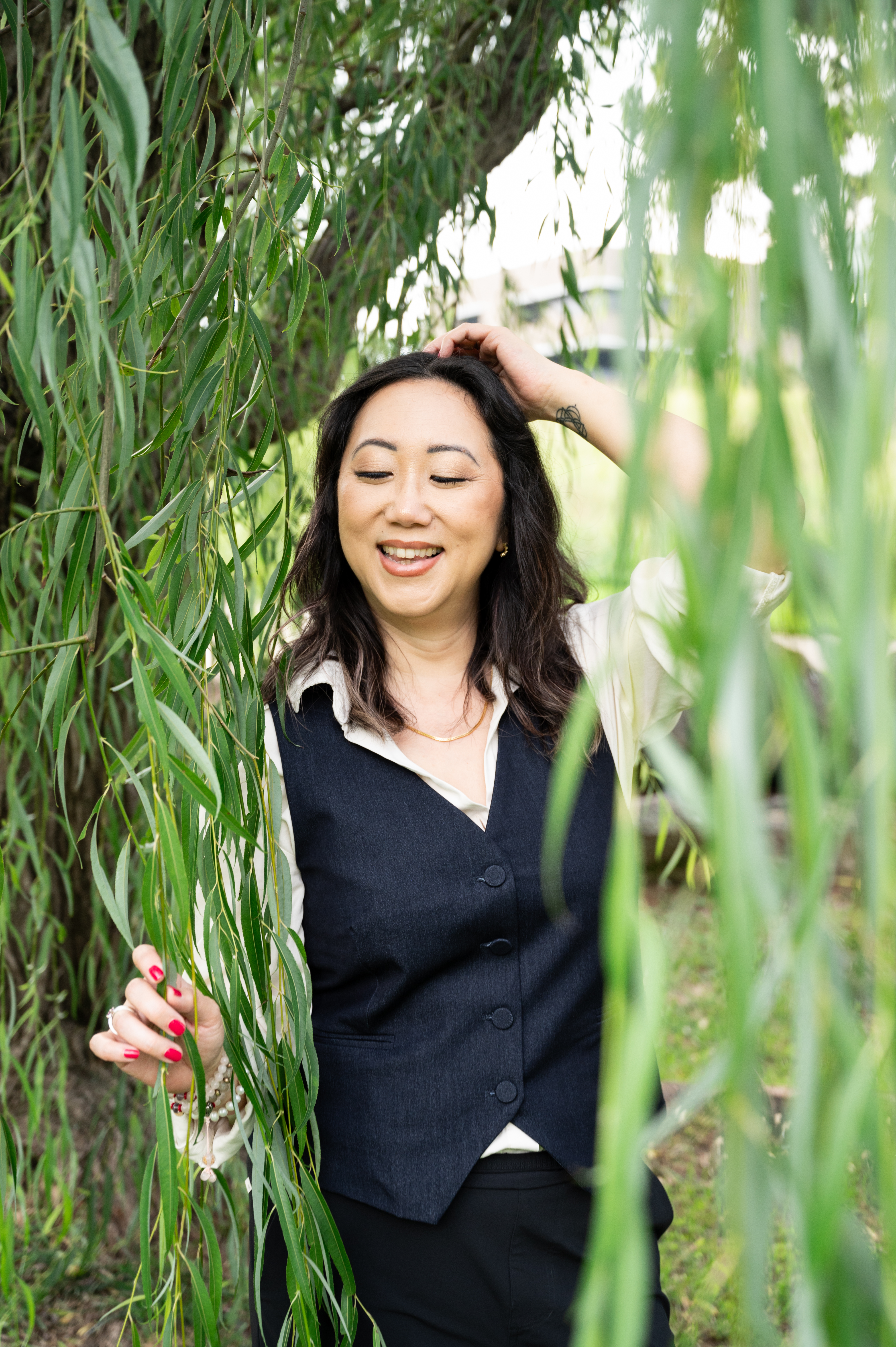 Sora Schilling among willow trees, smiling at the camera