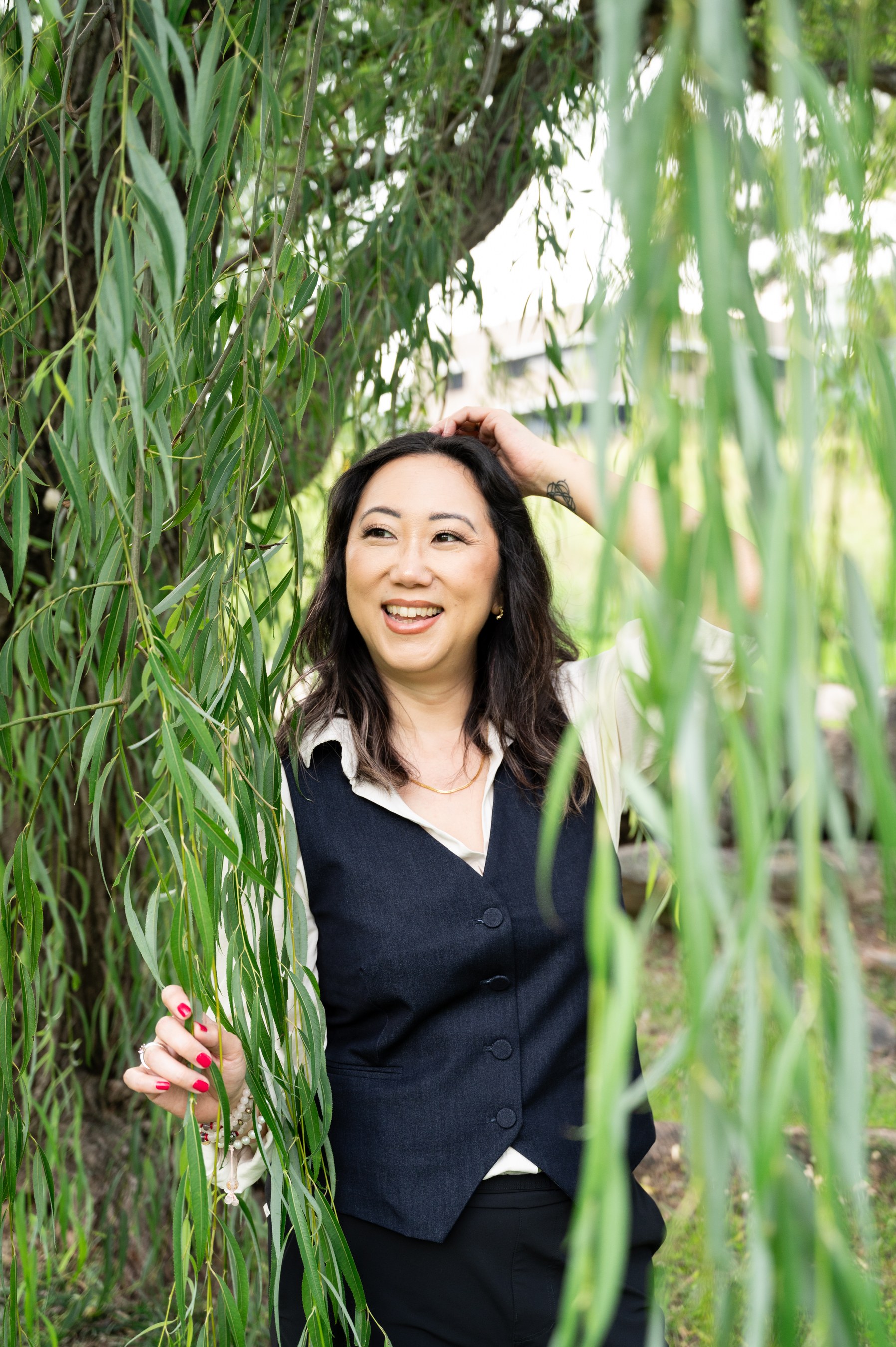 Sora Schilling smiling among willow branches