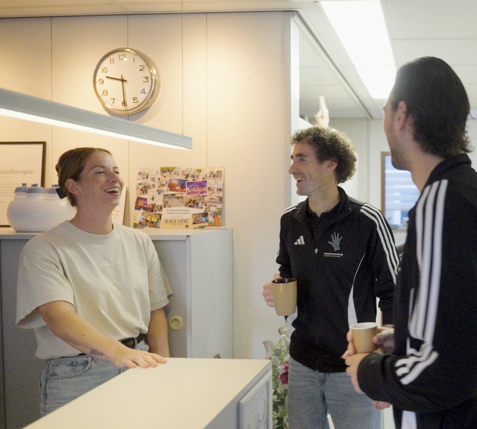 De secretaresse en collega's lachen samen bij de balie