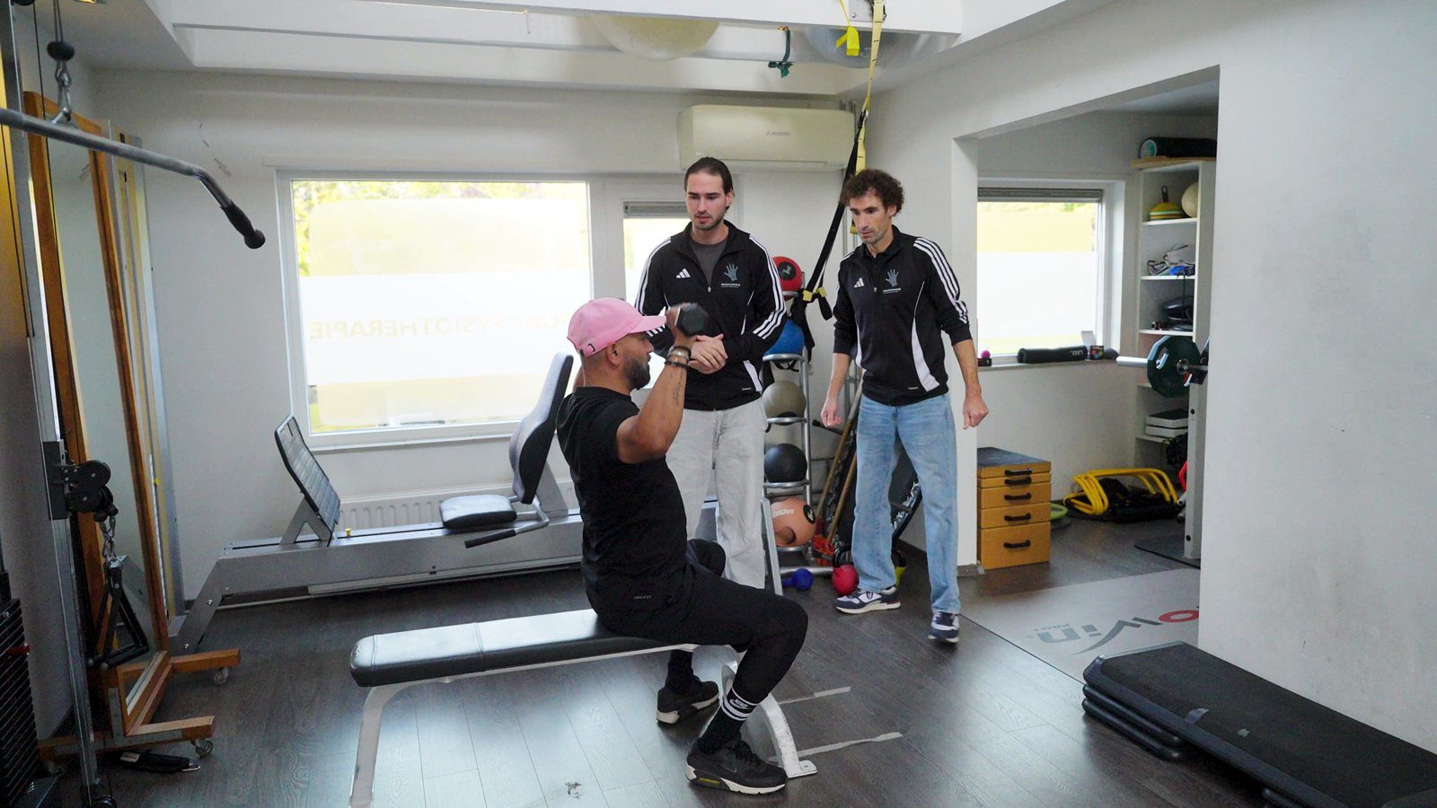 Collega's begeleiden een sporter in de oefenzaal