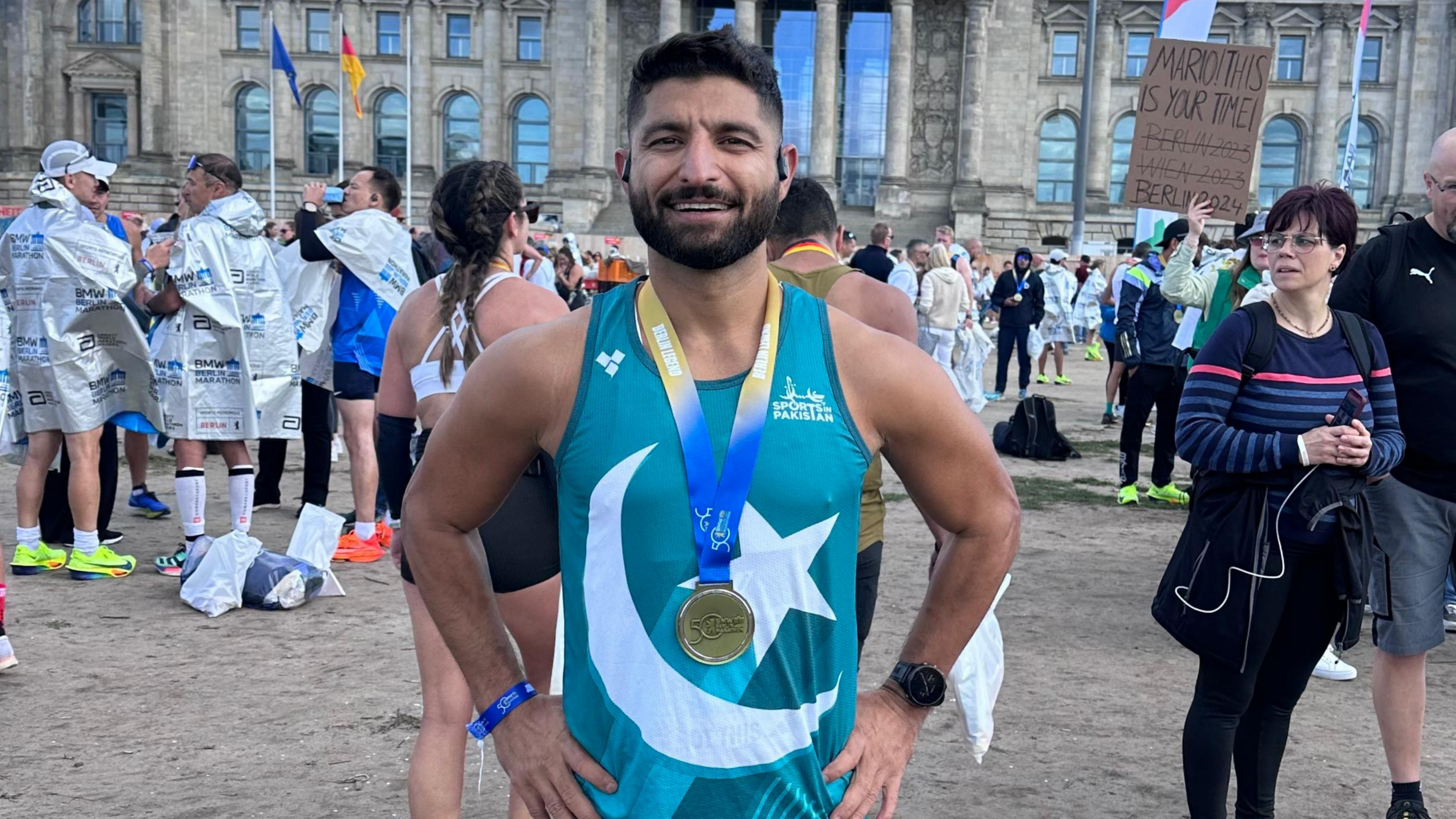 Shah Faisal Khan wearing his Berlin Marathon medal in front of the Reichstag