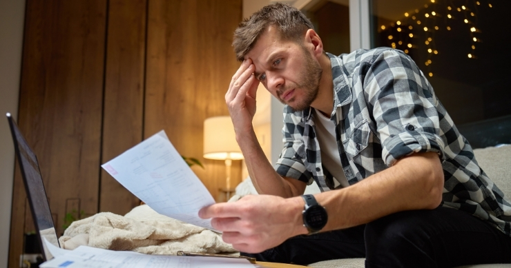 Individual reviewing expensive hospital bills after being uninsured during medical emergency. Individual reviewing expensive hospital bills after being uninsured during medical emergency.