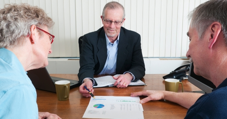 Couple meeting with financial advisor to discuss retirement planning and future income strategies.