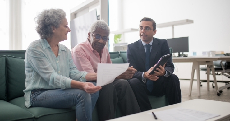 Financial advisor helping a couple create a comprehensive retirement plan. Financial advisor helping a couple create a comprehensive retirement plan.