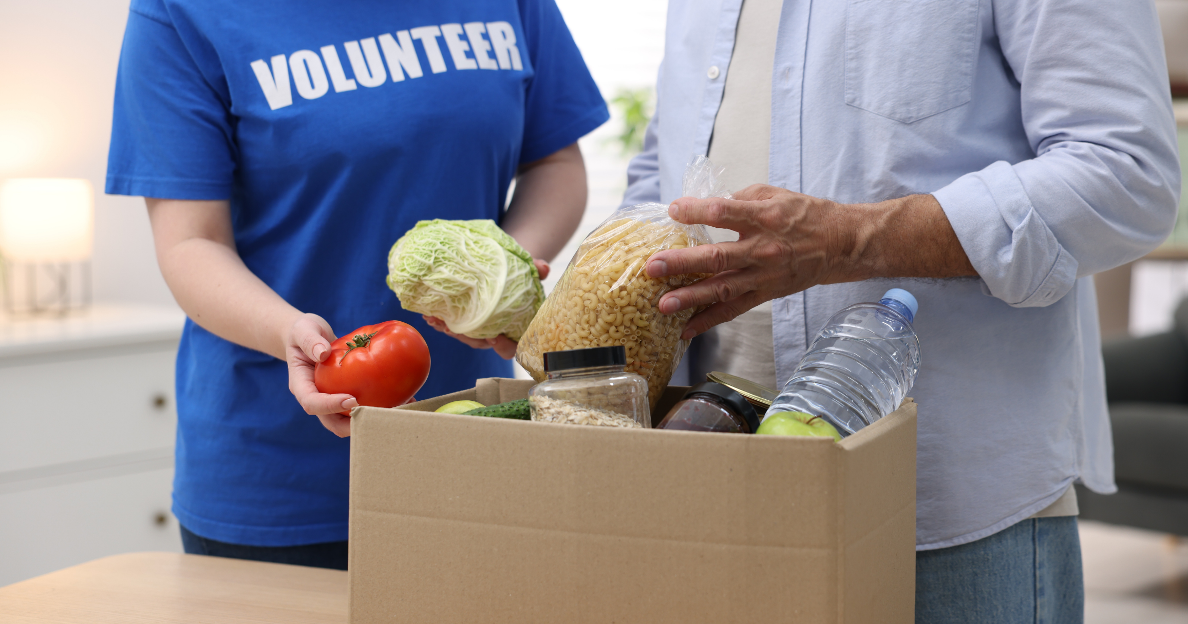 Volunteer handing a nutritional food package to a CSFP program recipient Volunteer handing a nutritional food package to a CSFP program recipient