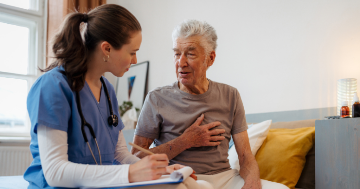 Senior patient receiving nursing care and medical treatment in a hospital room.