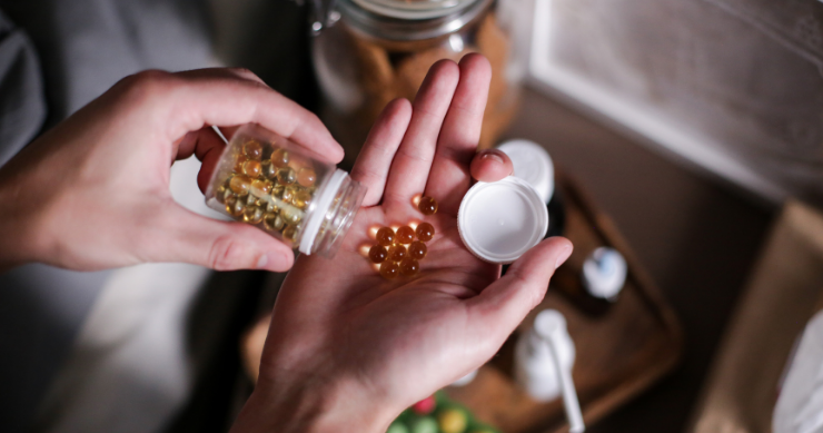 Persona mayor organizando sus pastillas semanales junto a una receta médica impresa. Persona mayor organizando sus pastillas semanales junto a una receta médica impresa.