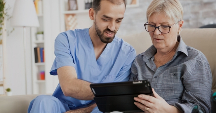 Un médico sosteniendo una tableta digital mientras explica opciones de seguro médico y programas de asistencia a un paciente. Un médico sosteniendo una tableta digital mientras explica opciones de seguro médico y programas de asistencia a un paciente.