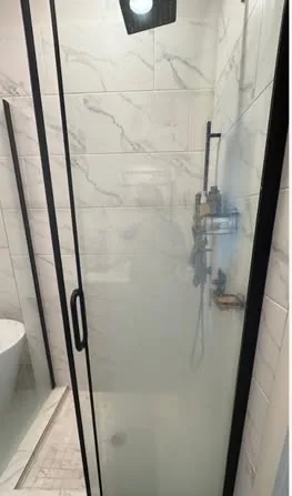 Shower glass door clouded with soap scum before cleaning