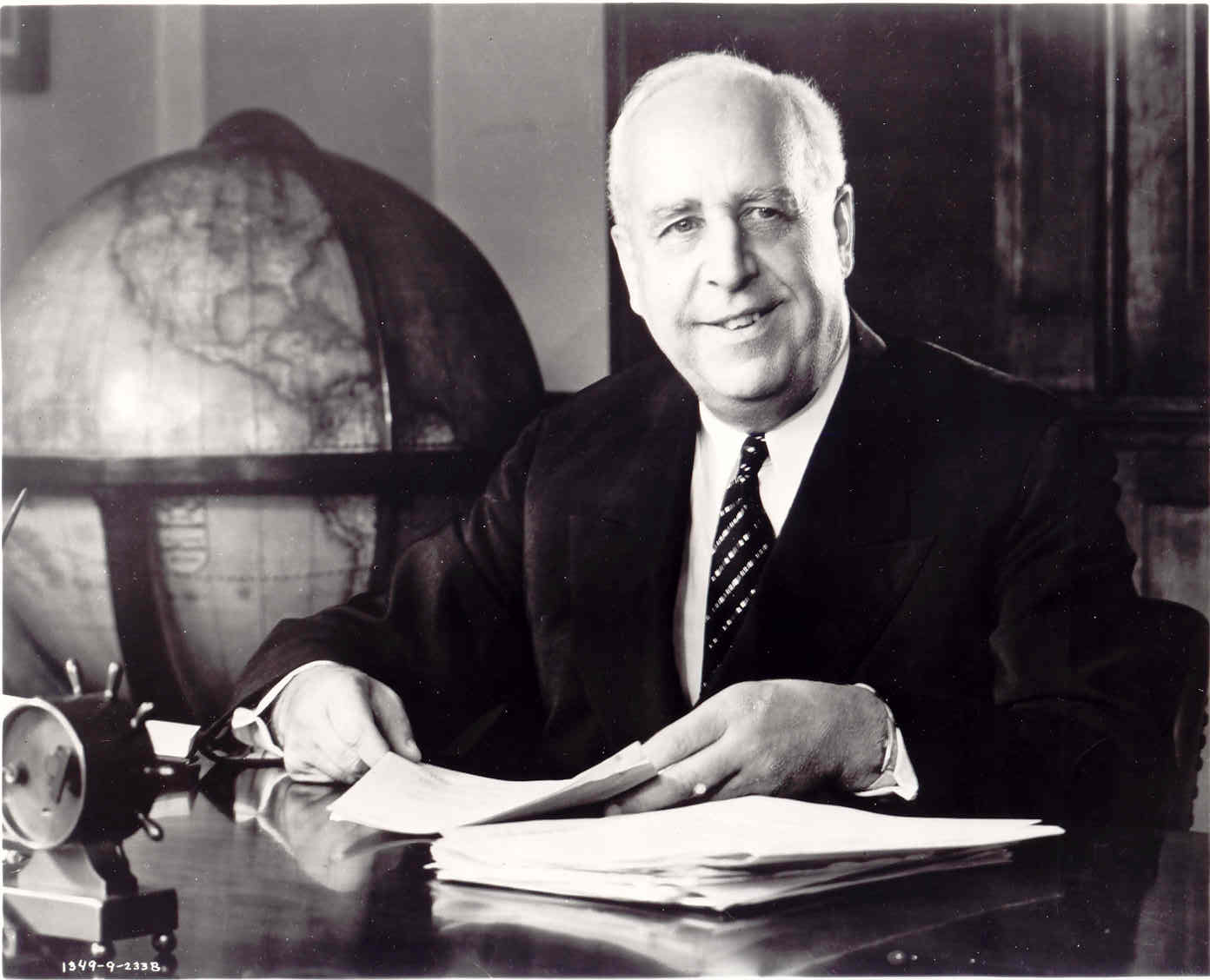 Formal archival portrait of Paul Weeks Litchfield, president of Goodyear Tire and Rubber Company, seated at his desk with a globe behind him — the visionary behind Litchfield Park, Arizona