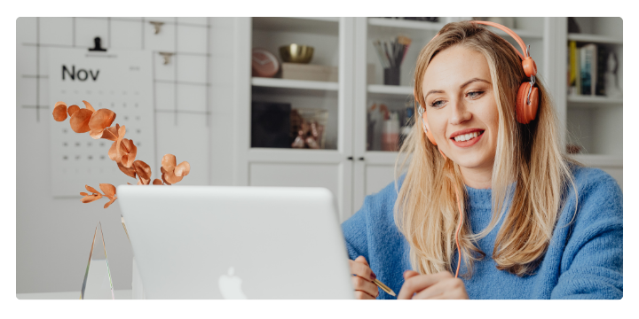 Woman smiling at desk wearing headphones Woman smiling at desk wearing headphones
