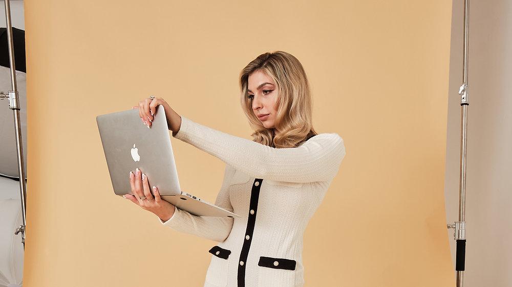 woman standing looking at her laptop