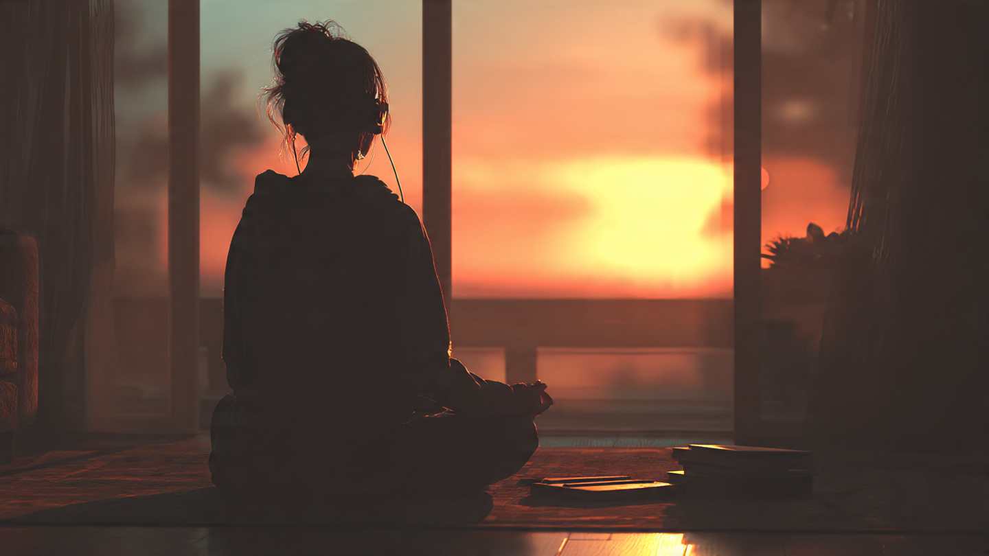 A person sitting in meditation at sunrise, facing a window with soft morning light. A small journal and their cell phone are face down on the floor They have earbuds and are sitting in the Lotus position with hands on their knees reprogramming peacefully. The scene conveys peace, intentionality, and the beginning of a new day. A person sitting in meditation at sunrise, facing a window with soft morning light. A small journal and their cell phone are face down on the floor They have earbuds and are sitting in the Lotus position with hands on their knees reprogramming peacefully. The scene conveys peace, intentionality, and the beginning of a new day.