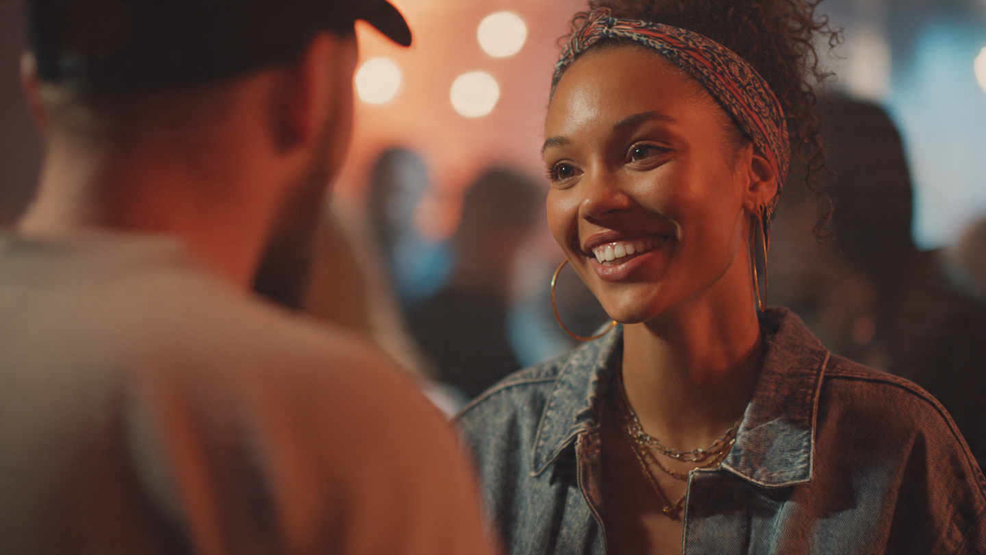 A close-up of two people having a conversation at an event. One person is leaning in slightly, making warm eye contact, while the other gestures animatedly. The background is blurred, emphasizing the connection. A close-up of two people having a conversation at an event. One person is leaning in slightly, making warm eye contact, while the other gestures animatedly. The background is blurred, emphasizing the connection.