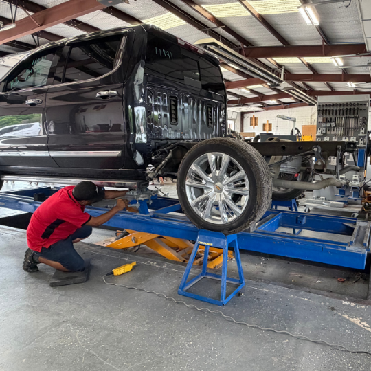 iCar certified technician prepping a black truck for frame straightening