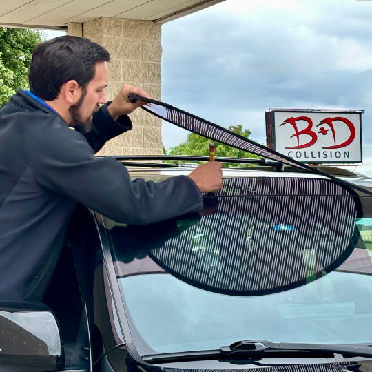 Estimator at B&D in Mesquite using a line reflector to find hail dents on a car