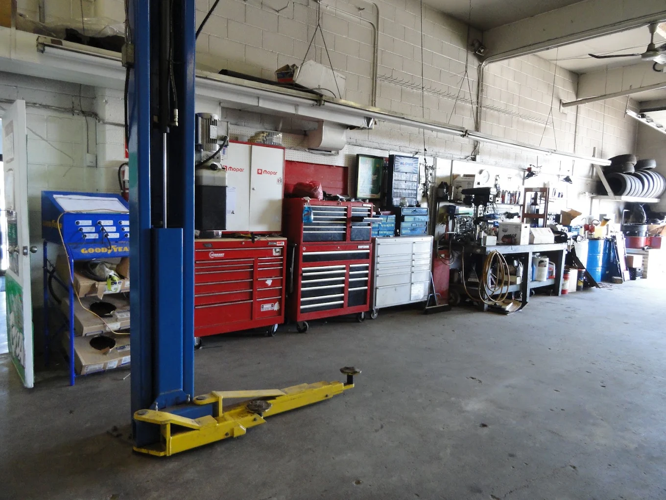 Two-post vehicle lift and tool chests in a JCo Auto service bay