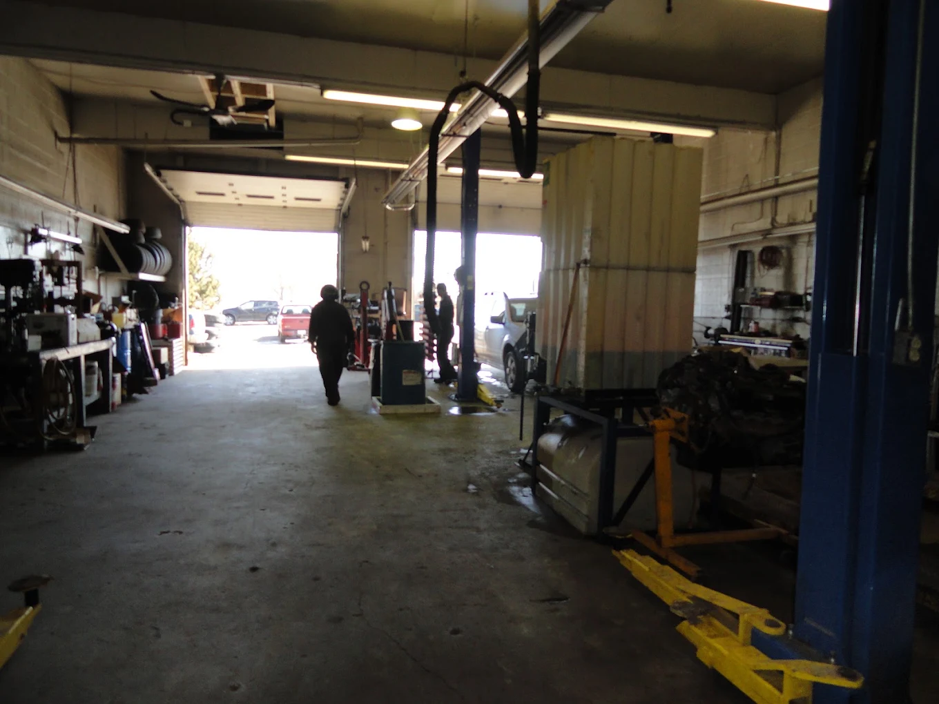 Inside JCo Auto's service bays, looking out the open bay door in SE Calgary