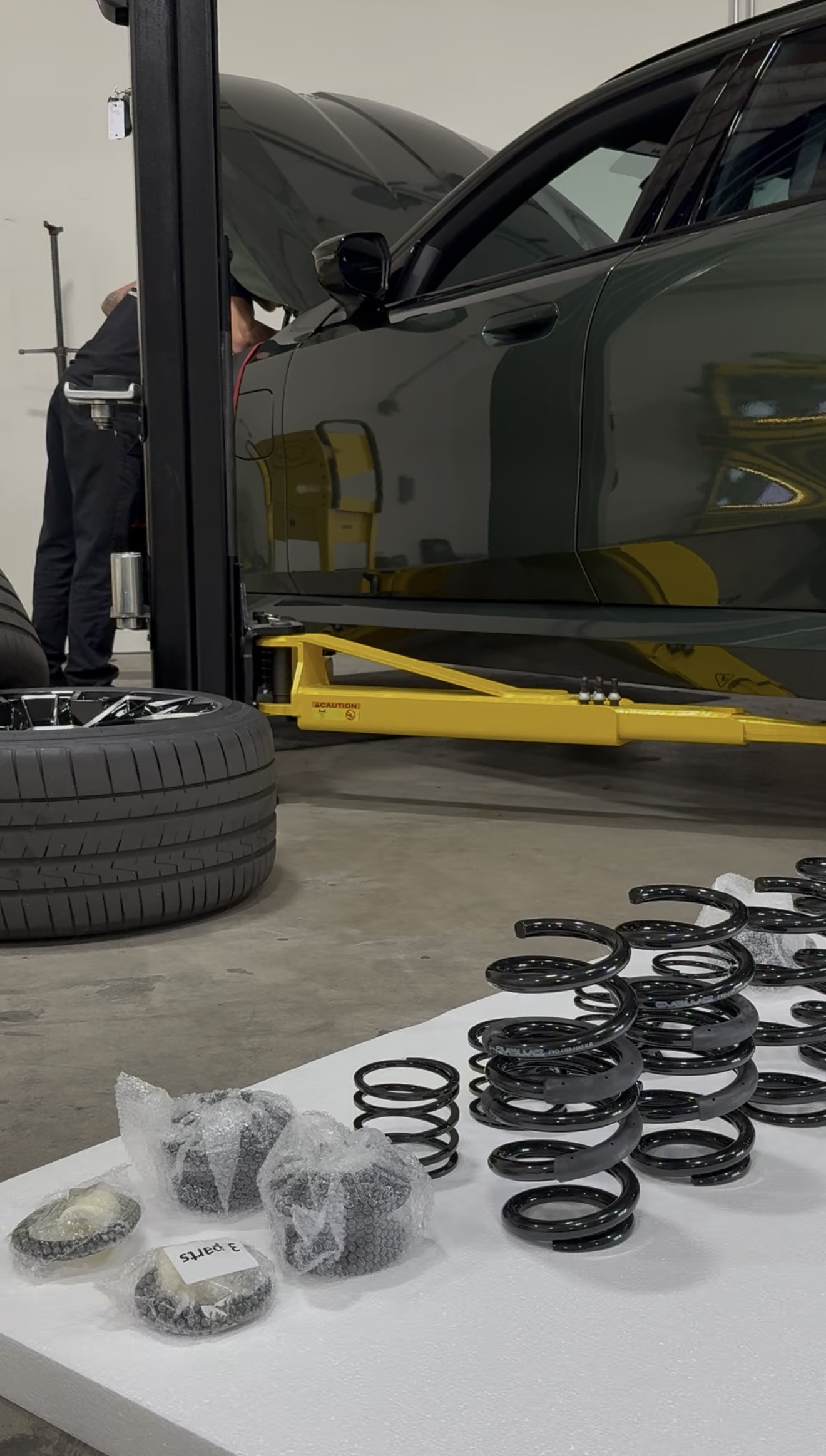 Technician inspecting BMW front suspension control arm and ball joint in a professional shop Technician inspecting BMW front suspension control arm and ball joint in a professional shop