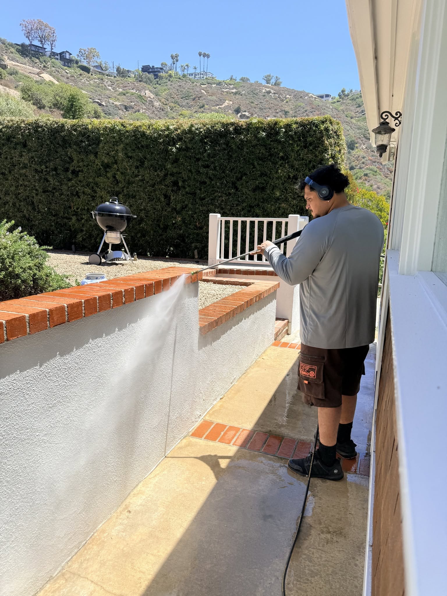 Pressure washing a residential exterior wall