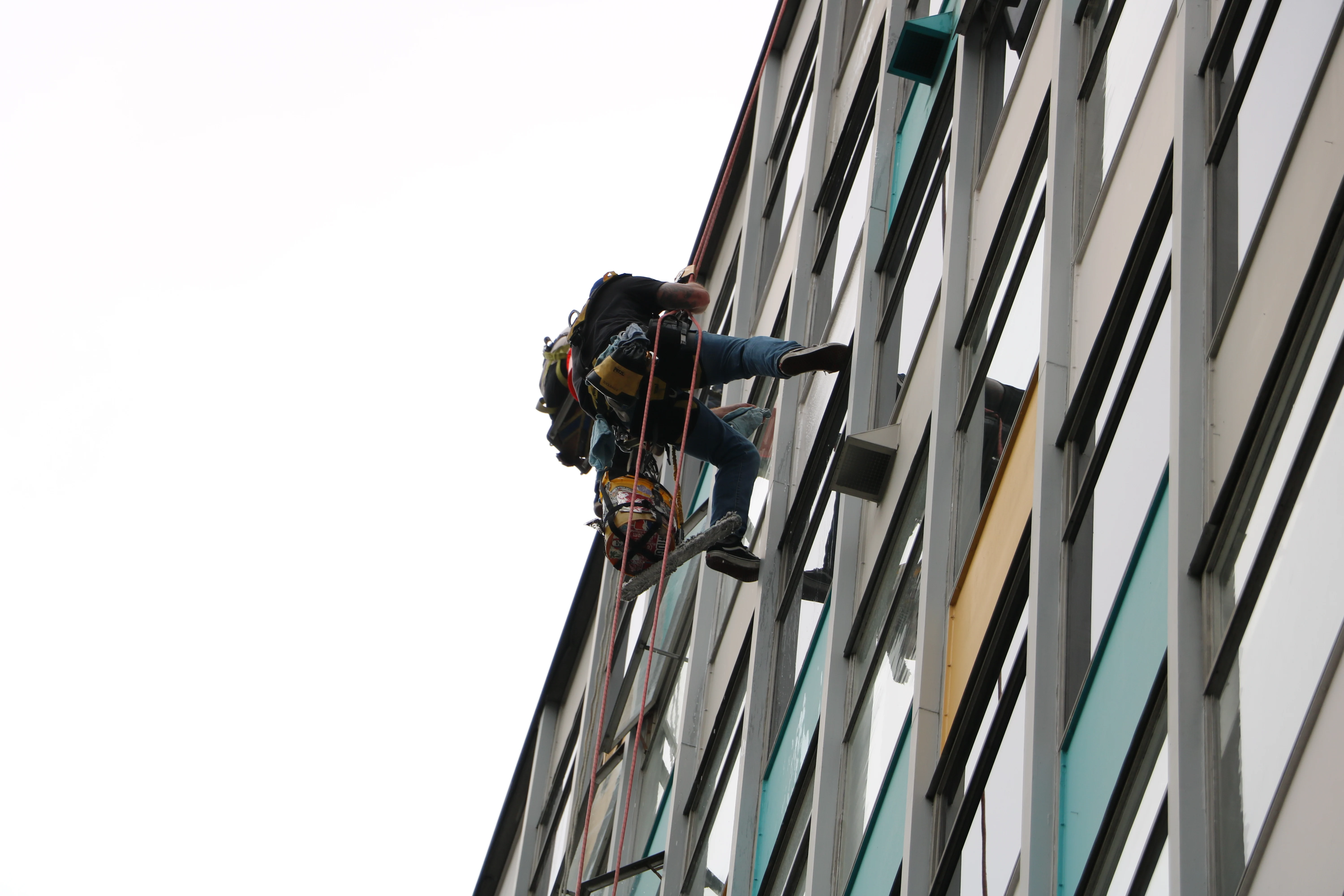 Wide view of a technician cleaning a commercial building exterior