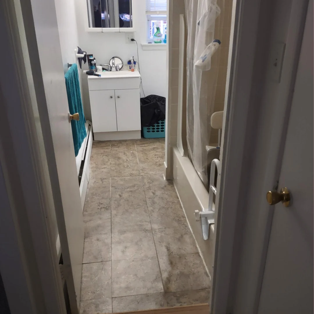 After: the bathroom floor cleared and cleaned, with the vanity and tub in view