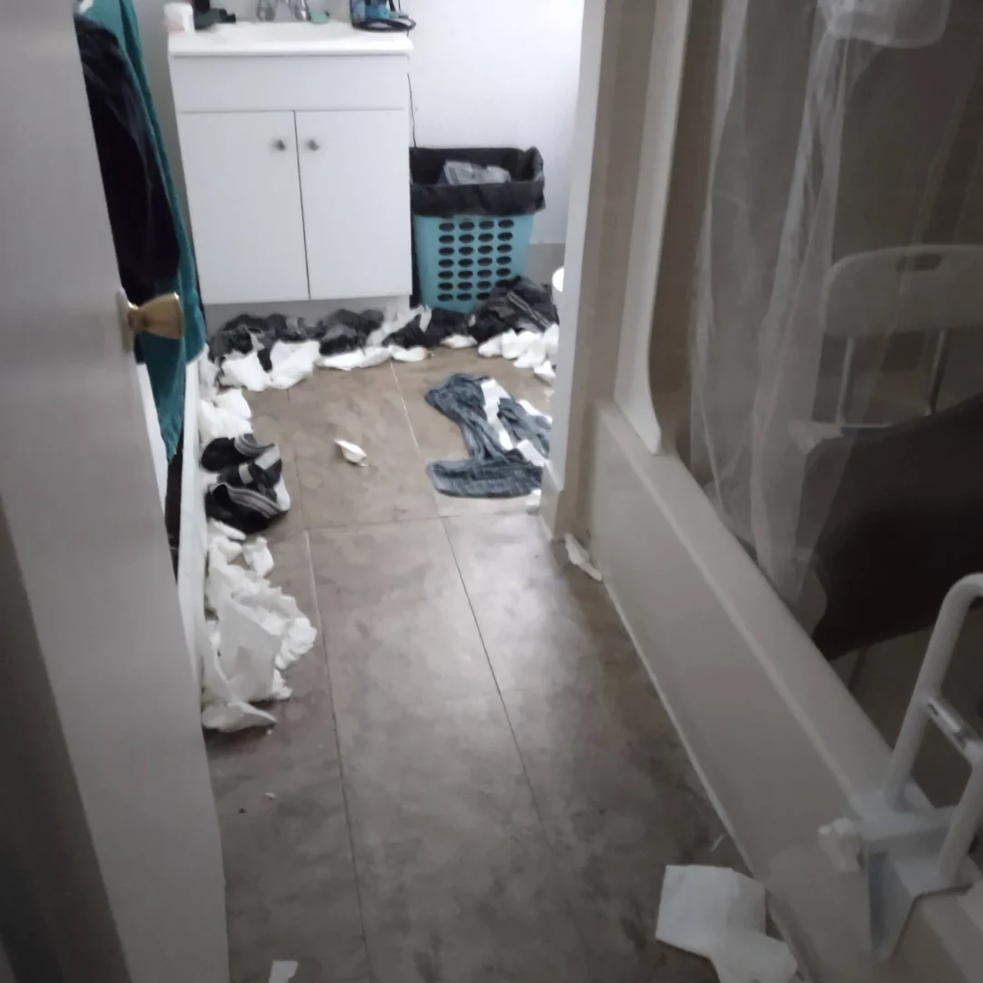 Before: clothes, shoes and paper spread across the bathroom floor