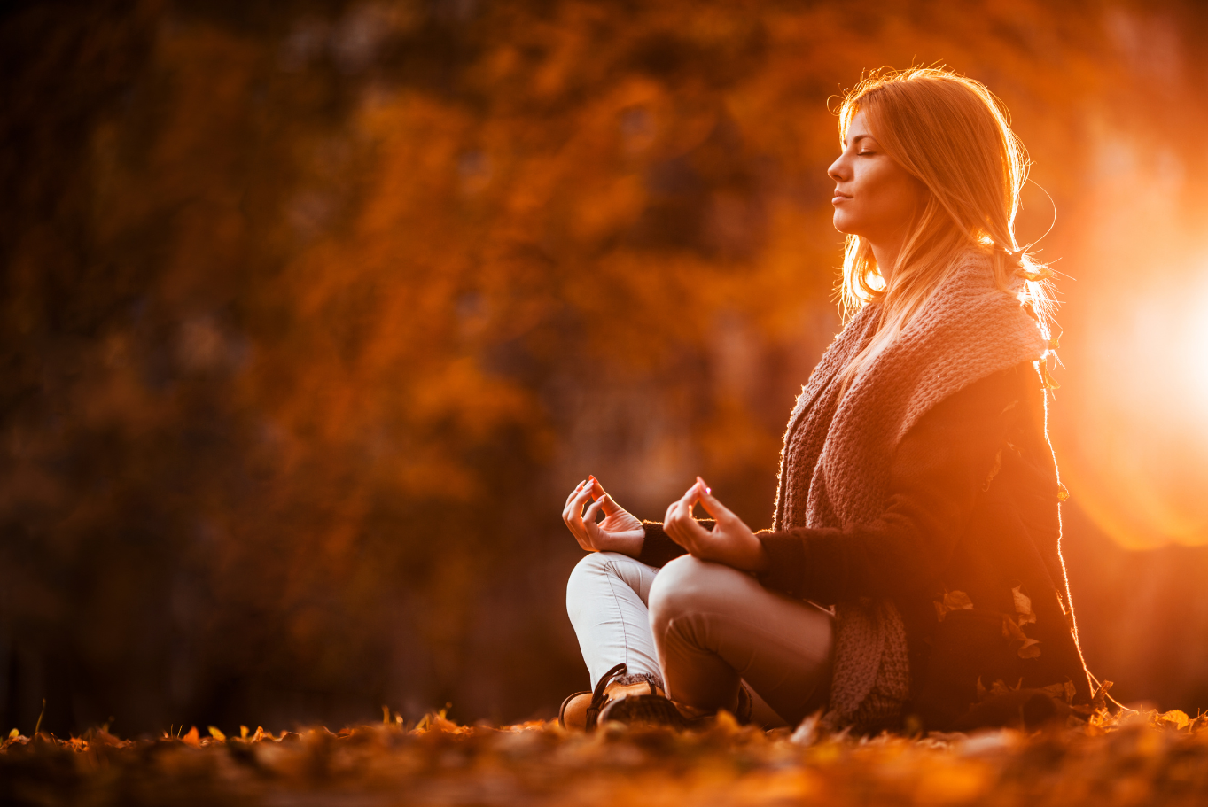 A serene image of a person meditating by a calm lake at sunrise, surrounded by soft glowing light. The scene conveys inner peace, clarity, and spiritual awakening.