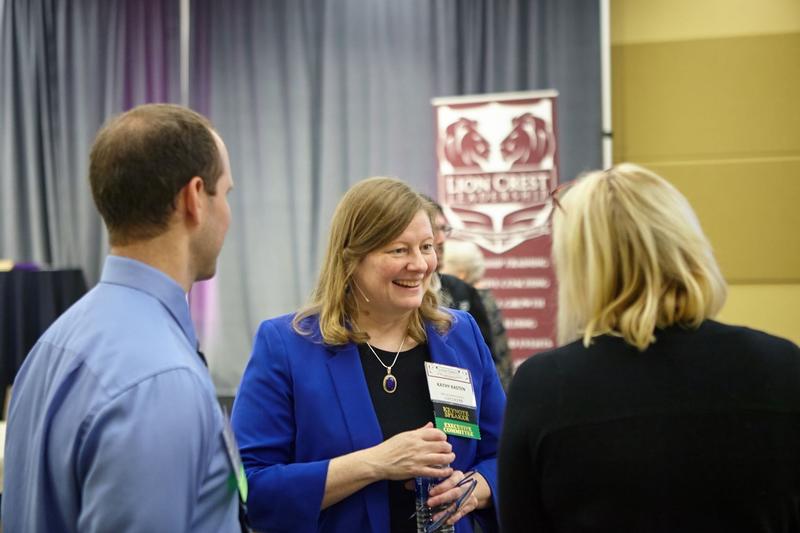 Kathy in conversation with two leaders at a Lion Crest event