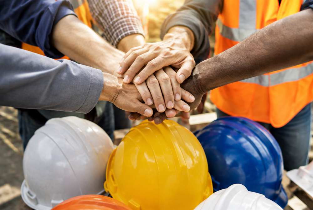 Members' hands joined together over a union table