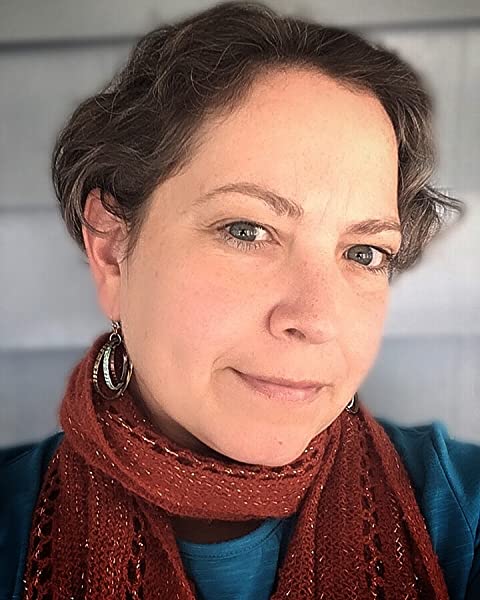 A woman with short brown hair and green eyes, wearing a blue shirt, blue hoop earrings, and an orange scarf.