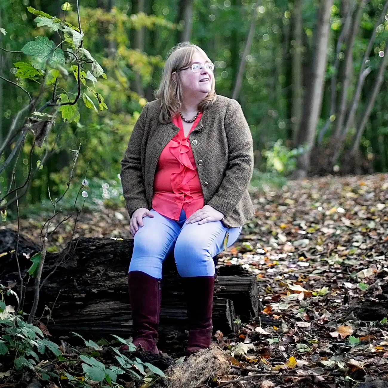Kathryn Dunn, cognitive behavioural hypnotherapist, sitting outdoors among trees