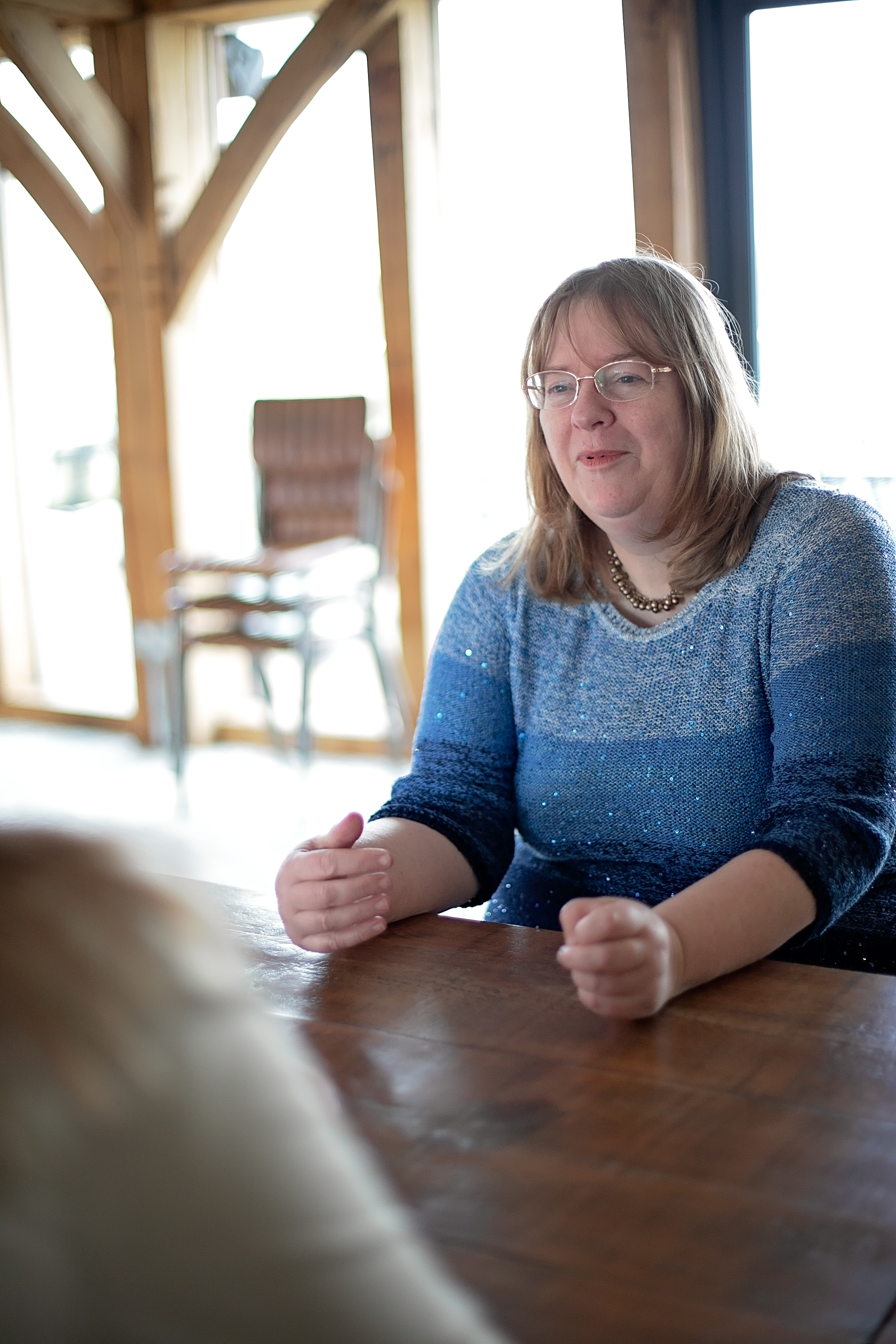 Kathryn Dunn listening, sitting across a table from someone