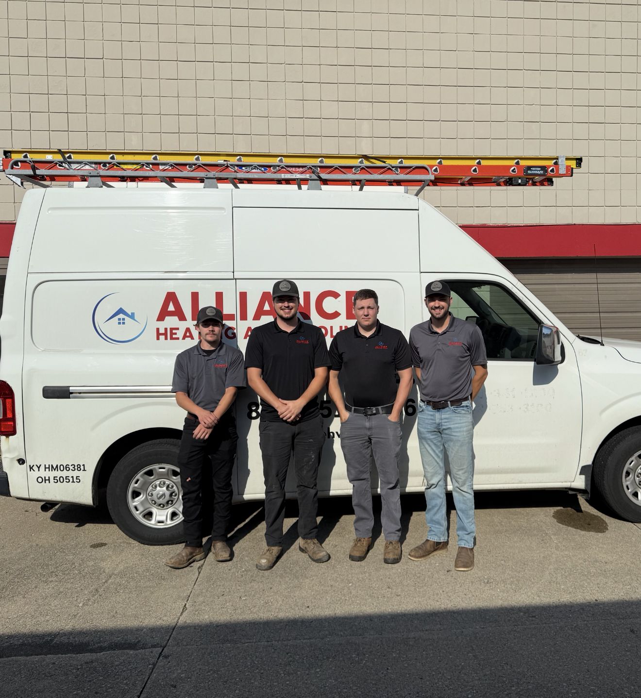 Four Alliance Heating and Cooling team members standing in front of a company van