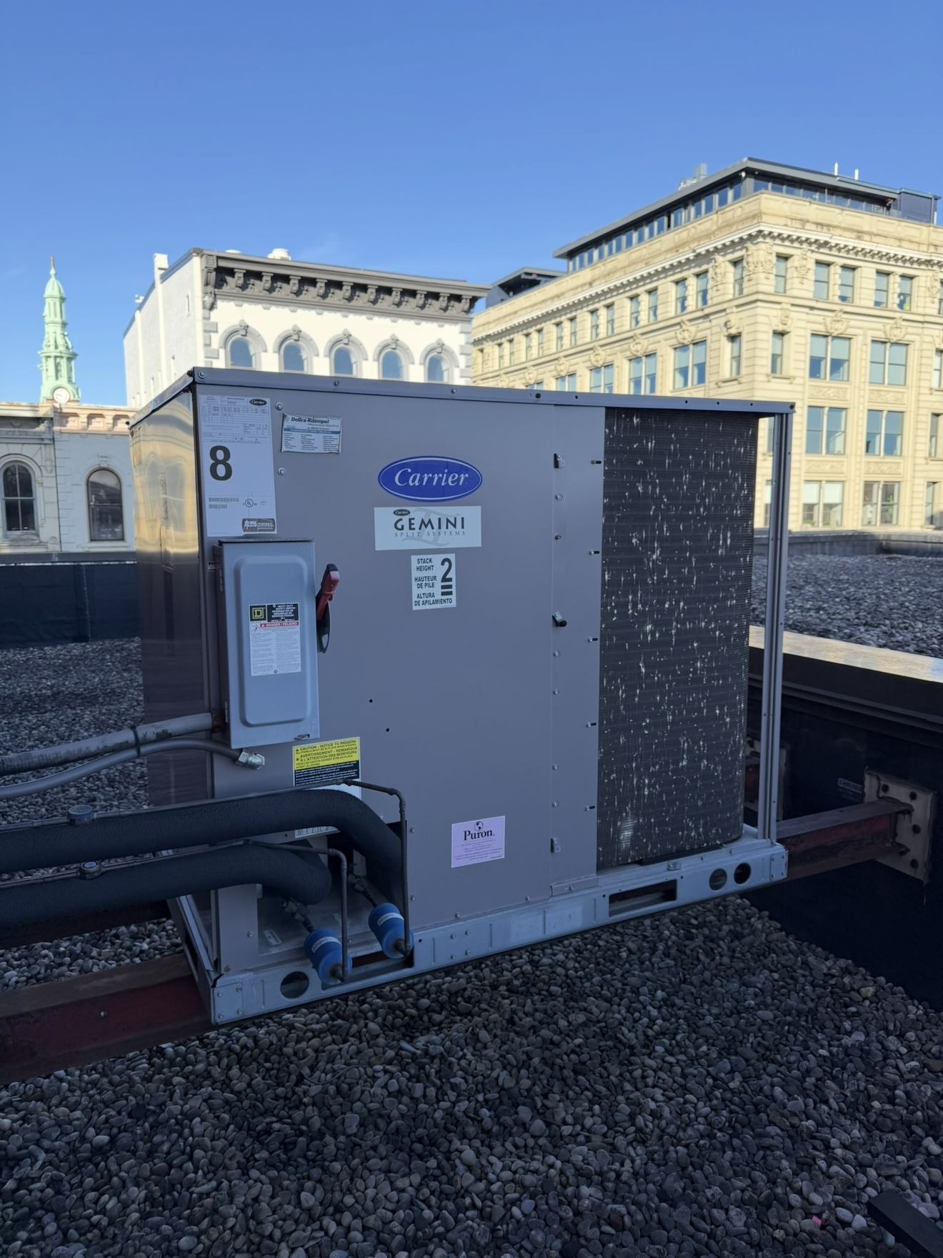 Carrier rooftop HVAC unit on a commercial roof with downtown Cincinnati buildings behind it