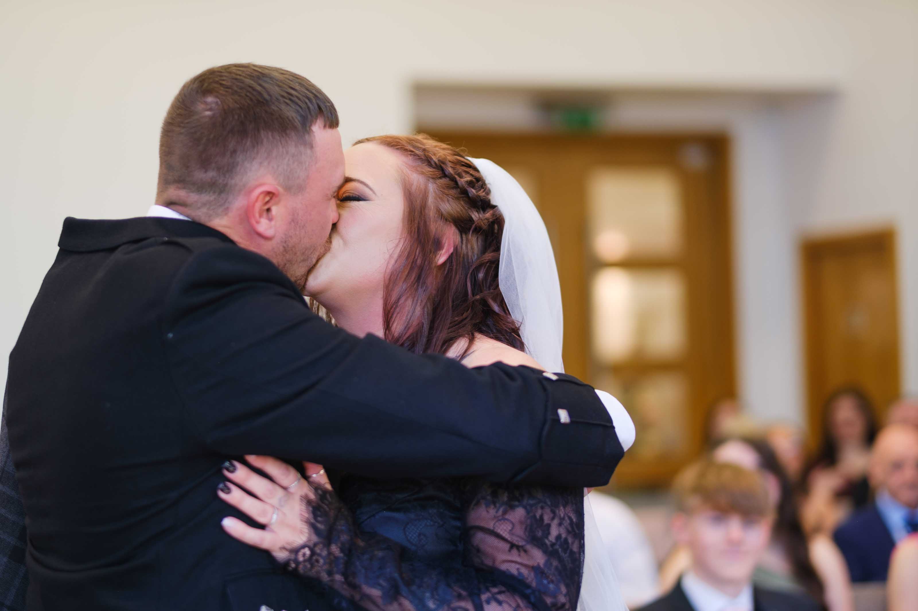 Couple exchanging first kiss at The Burns Monument, Ayrshire