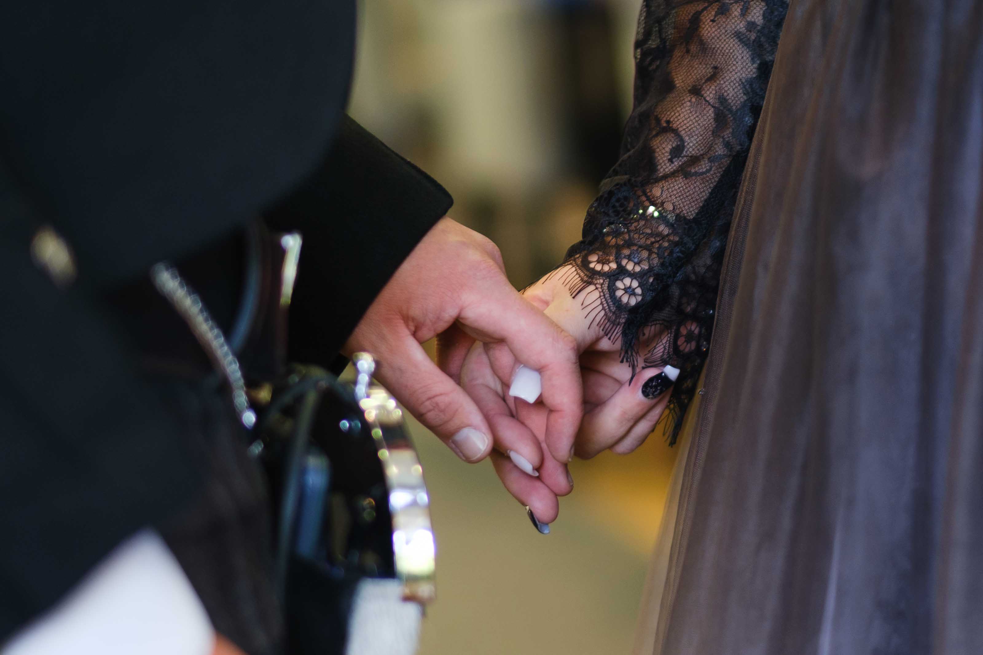 Bride and groom holding hands during wedding ceremony at The Burns Monument Centre