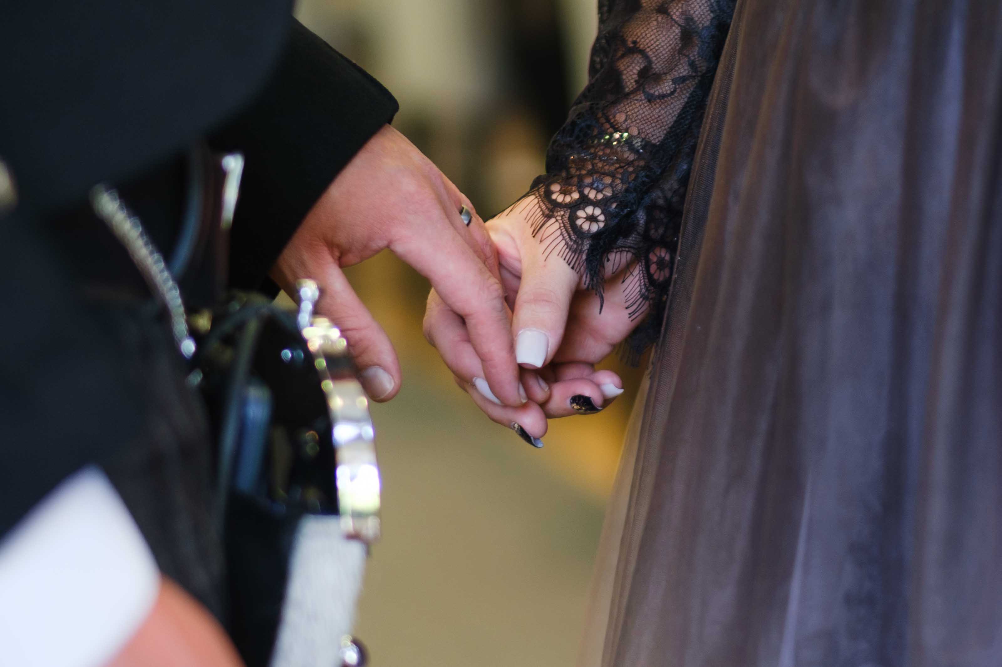 Bride and groom caressing hands during wedding ceremony