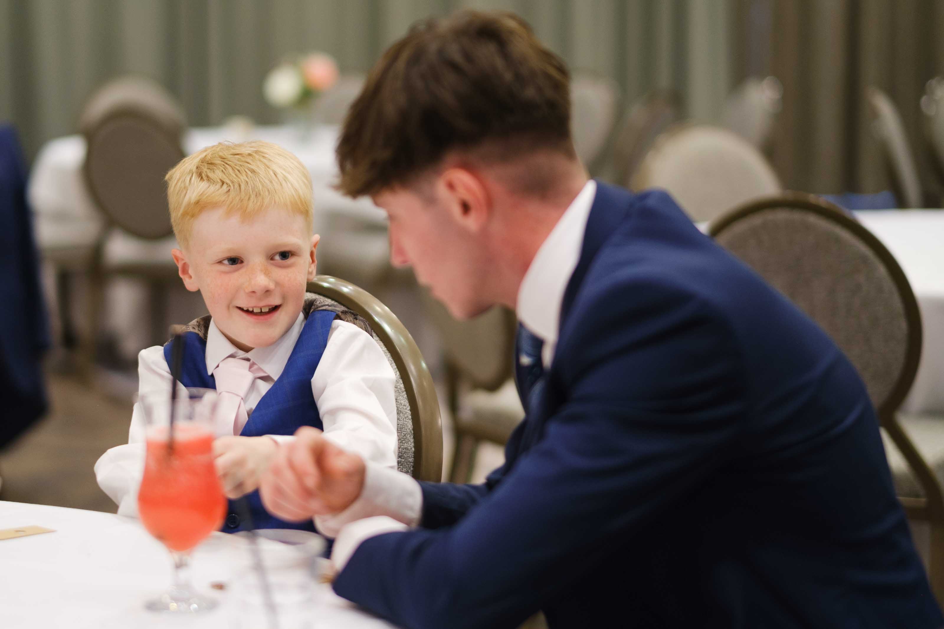 Wedding guest and child playing heads or tails during reception